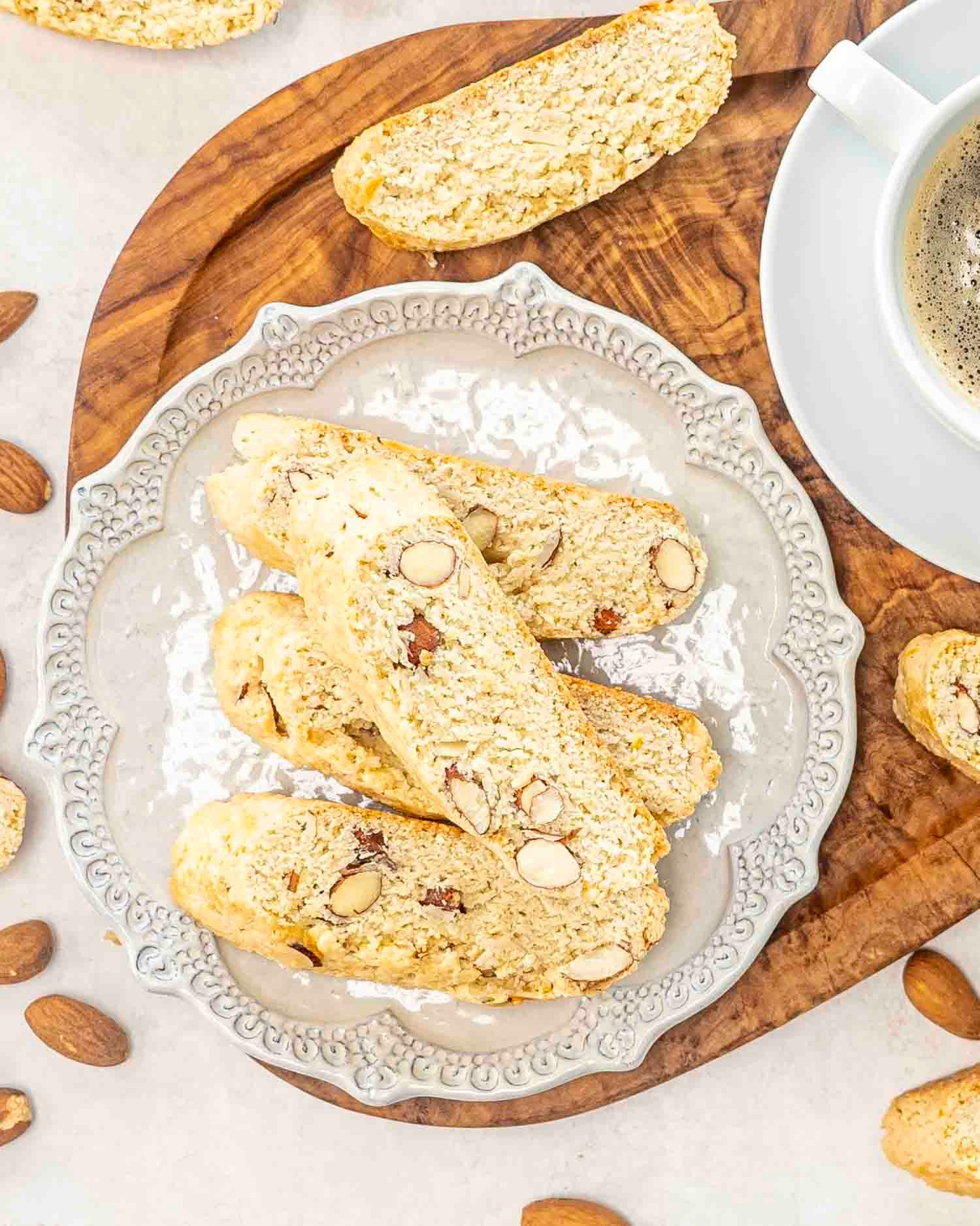 almond biscotti on a beige plate on a cutting board.