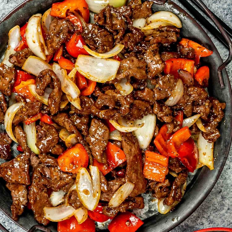 black pepper beef in a metal serving plate.