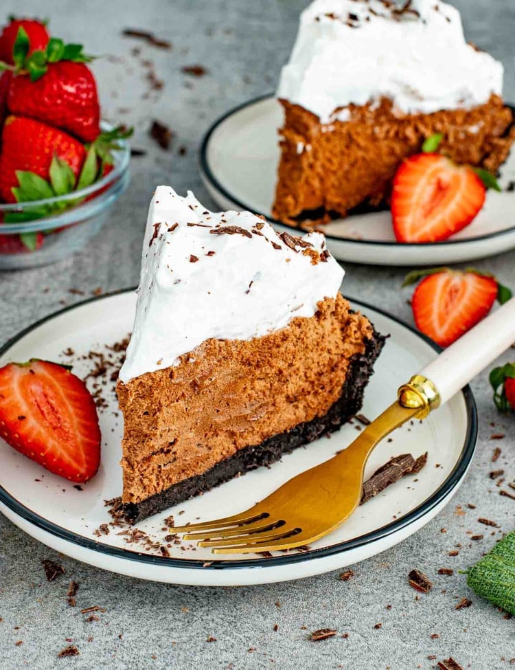 a slice of French silk pie on a dessert plate garnished with chocolate shavings.