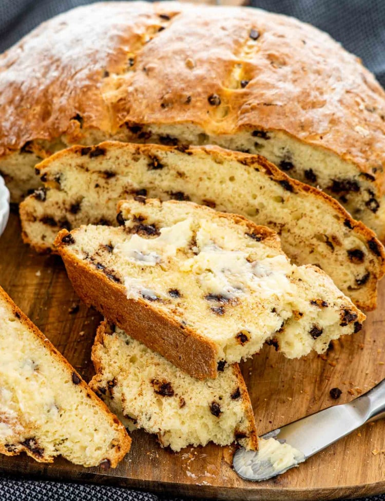 irish soda bread with chocolate chips on a cutting board with a few slices.