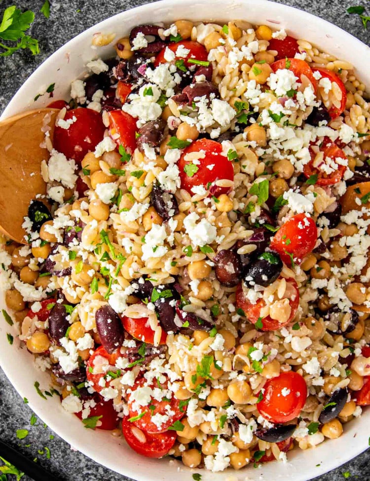 freshly made mediterranean orzo salad in a big white bowl.