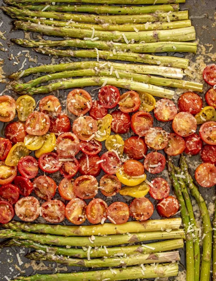 roasted asparagus and tomatoes on a baking sheet.