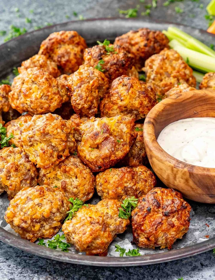 sausage balls in a metal plate along some ranch dressing.